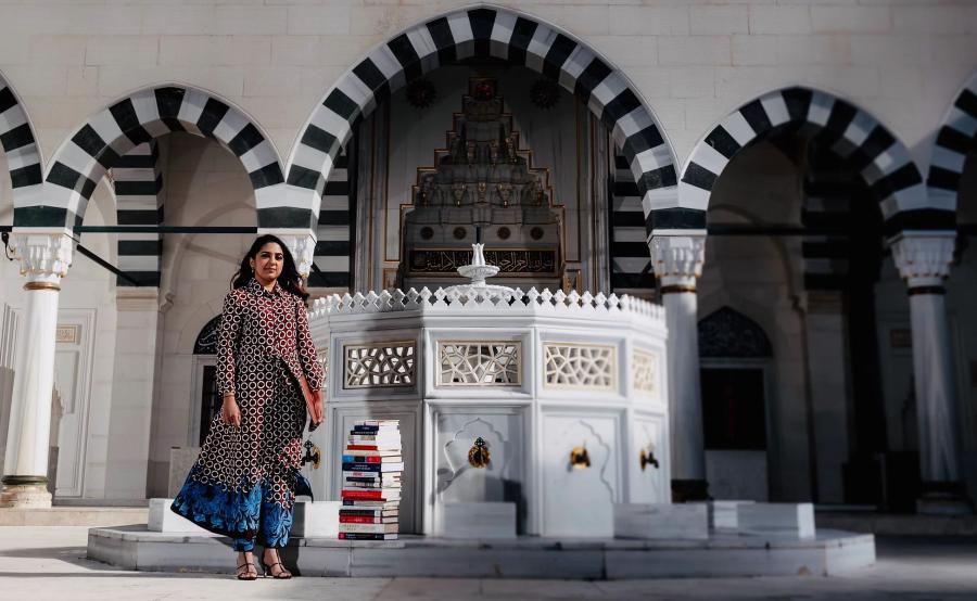 Asma Uddin outside mosque with books