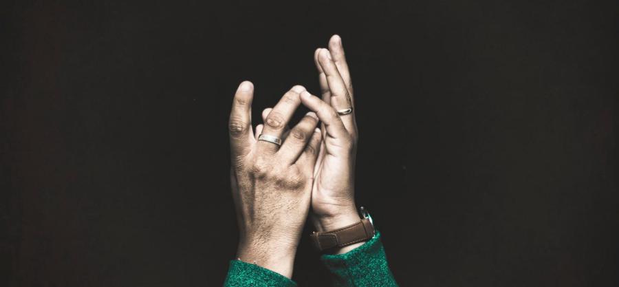 Hands facing upward against black background