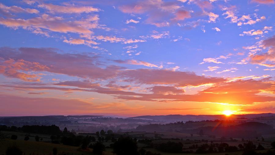 sun setting over mountains and landscape