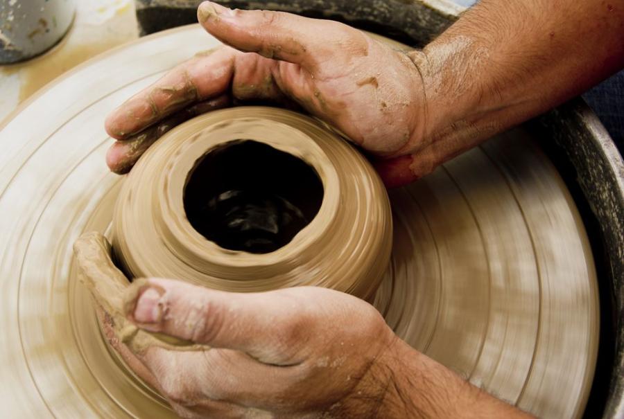 potter's hands at wheel with clay