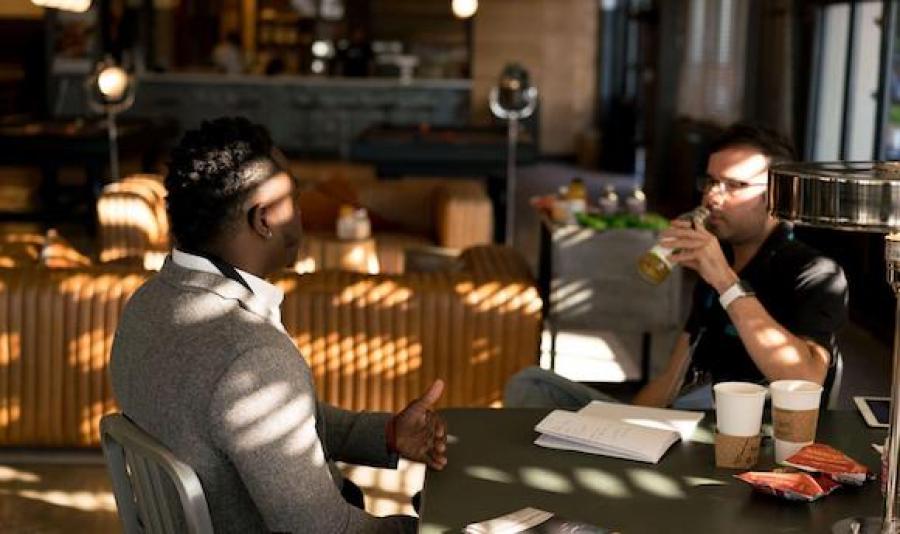 Two men in conversation at coffee shop