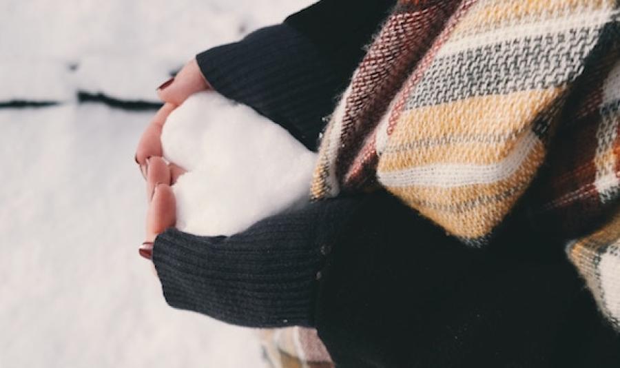 Hands holding snow hear