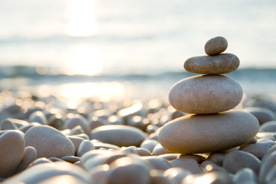 stack of four smooth stones on a sunny beach