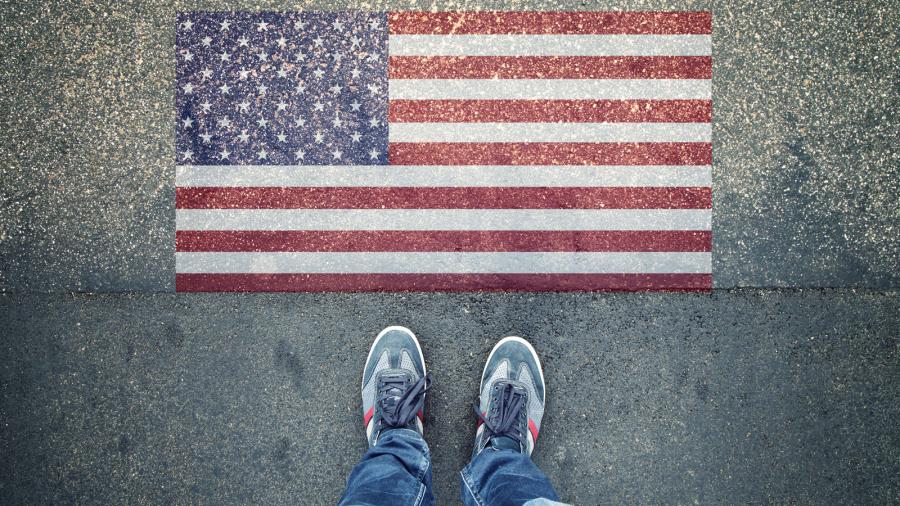 two feet in front of US flag painted on sidewalk