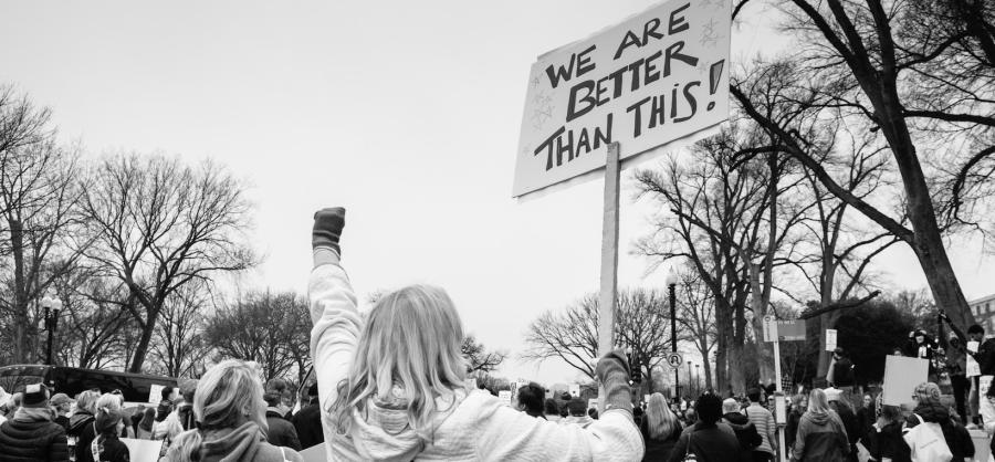 Woman holding sign saying "We are better than this" at Women's March in DC