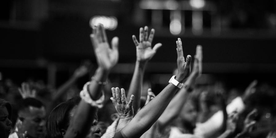 Image of people worshipping. Photo is in black and white.