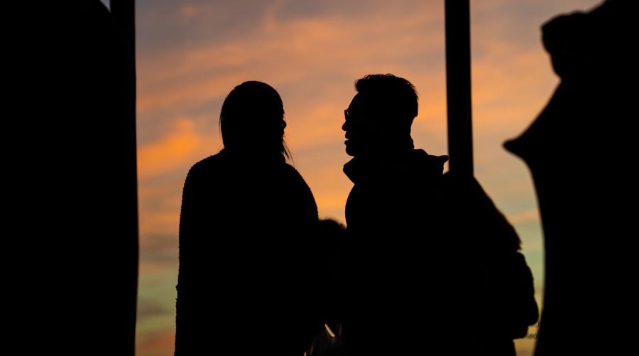 Silhouette of two people in conversation