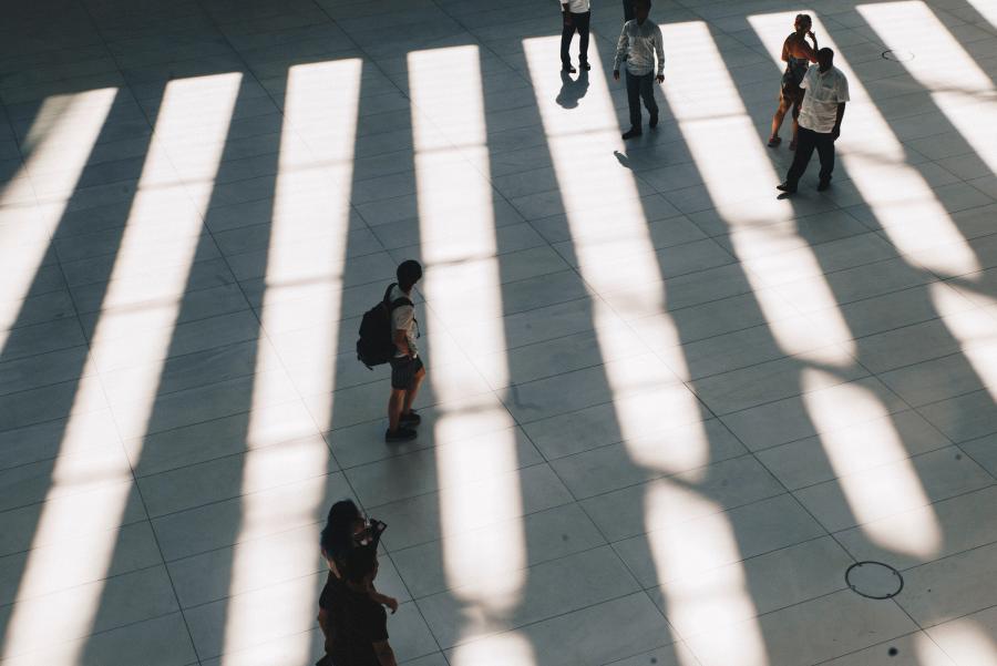 Urban pedestrians with shadows striping pavement