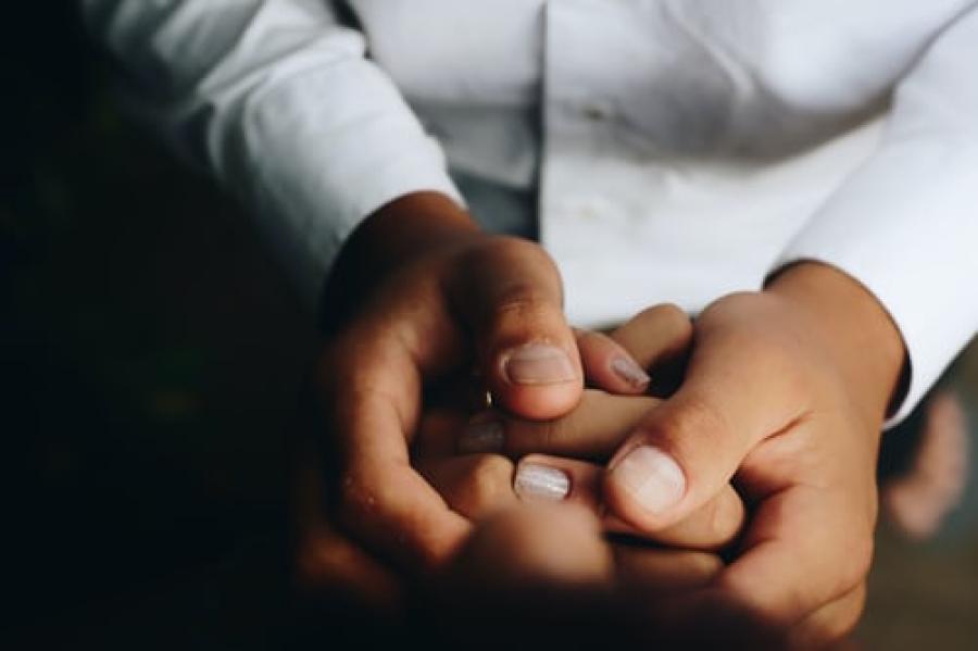 holding hands facing one another