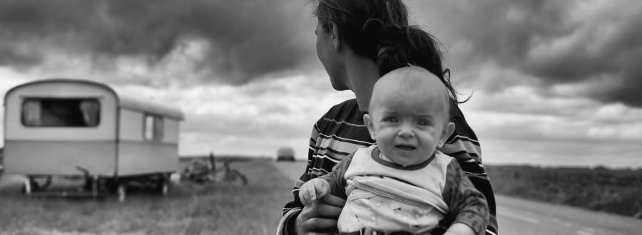 Woman with baby near trailer home.